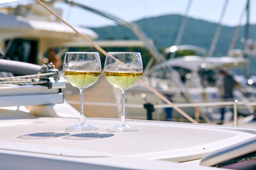 Pair of wineglasses against the yacht