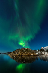 Fototapeta na wymiar Green aurora borealis northern lights water reflection