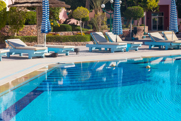 Chaise longues near a swimming pool. Concept of spa, rest, relaxation, holidays, resort