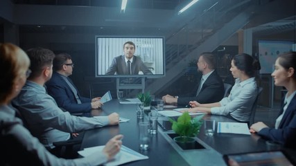 In the Conference Room Group of Directors, Investors and Businessmen Making Late Night Video Conference Call To Talk with International Corporation Representative - Powered by Adobe
