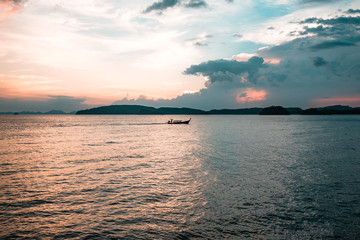 small fishing boat in Thailand in the midle, sunset cloudy  sky, clean water