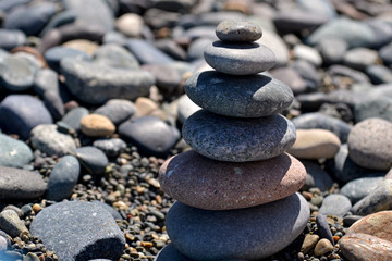 Fototapeta na wymiar a pyramid of pebbles on a blurred background of stones