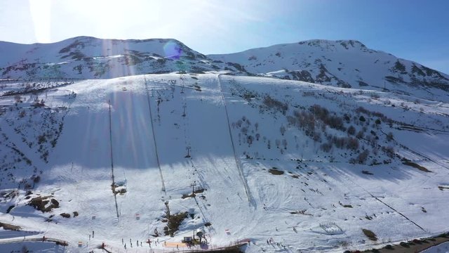 Aerial, reverse, drone shot away from the Leitariegos ski resort and the mountains, on a sunny day, in Leon, Spain