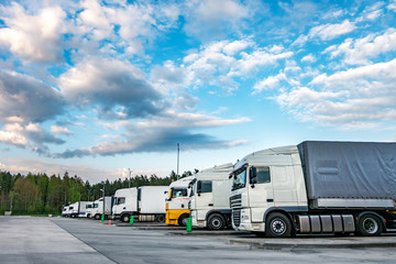 Fototapeta na wymiar Trucks in a row with containers in the parking lot near forest , Logistic and Transport concept