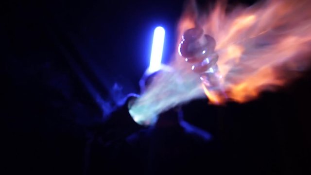 Close up view of glass blowing with a flame in the dark
