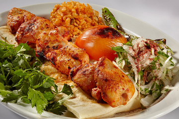 chicken kebab with bulgur pilaf, observable peppers and tomatoes