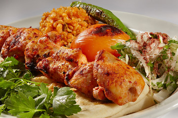 chicken kebab with bulgur pilaf, observable peppers and tomatoes