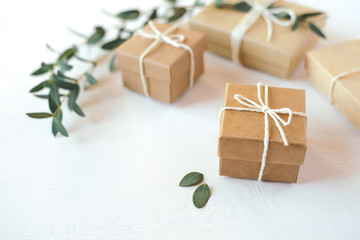 Craft gift boxes on white wooden background. Copy space for text. Eco concept