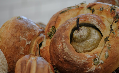 A round loaf of sour dough bread, baked with a pear in the centre and herbs sprinkled on top.