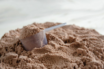 Product photograph of spoon or measuring scoop of whey protein. Whey protein powder sports...