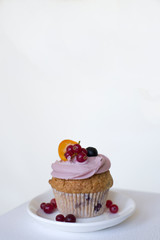 Sweet cupcake with fruits and berries on a white background