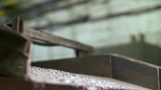 Metal pieces falling into a box from recycling processing machine