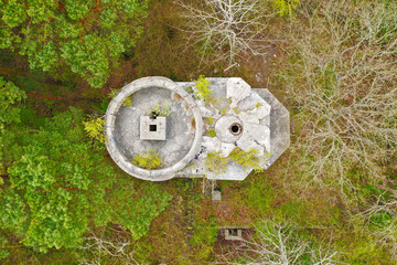 Aerial top down view on ruined and old tower bunker hidden in deep forest © FStockLuk