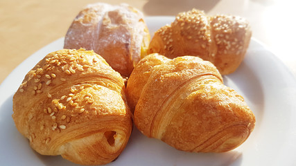 fresh croissants with natural sunlight on plate traditional french breakfast with coffee 