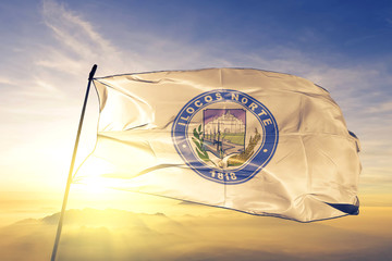 Ilocos Norte province of Philippines flag waving on the top sunrise mist fog