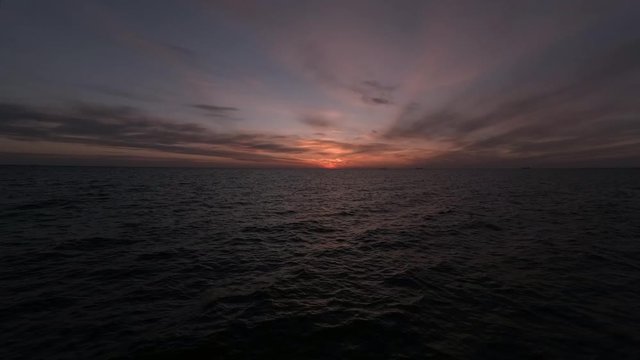 Vary dark and moody sunrise timelapse in a very dark, early spring beach.