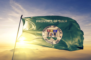 Sulu province of Philippines flag waving on the top sunrise mist fog