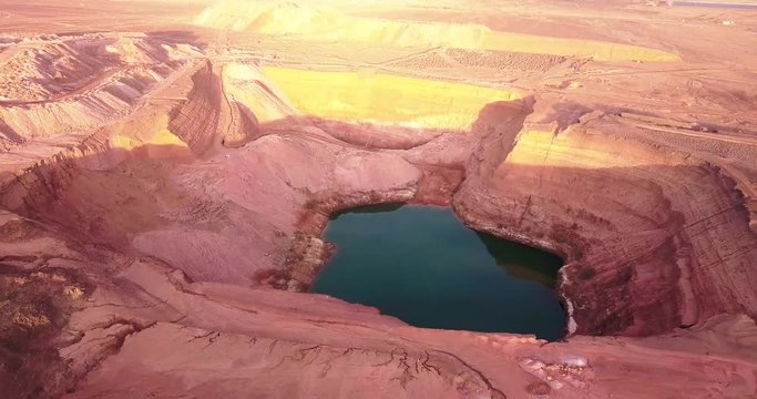 Hidden lost spring lake in desert negev of Israel Agam timna. Aerial shoot above desert Oasis at Timna, Red cliff brown mountain rocks in the middle of the Arava, Kibbutz Samar Eilat springs.