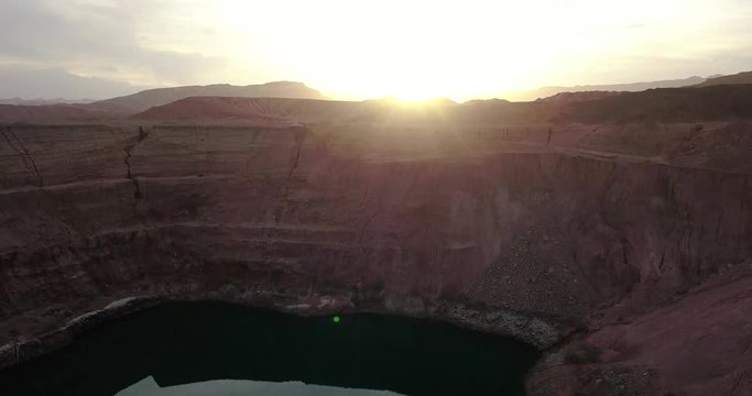Desert negev of Israel Hidden lost spring lake Agam timna. Sun flare over desert Oasis at Timna, Aerial shoot above Red cliff brown mountain rocks in the middle of the Arava