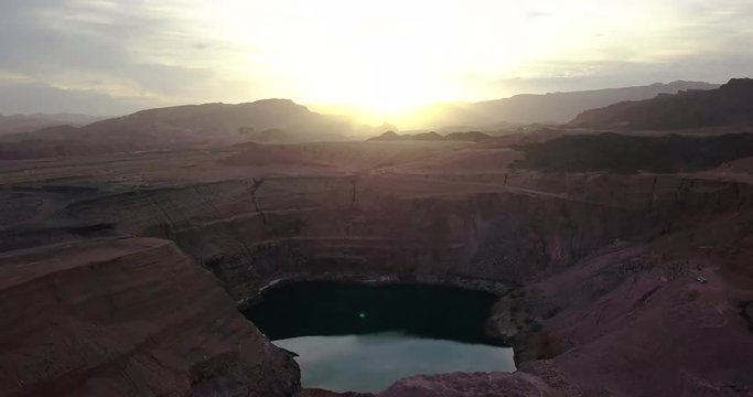 Desert negev of Israel Hidden lost spring lake Agam timna. Sun flare over desert Oasis at Timna, Aerial shoot above Red cliff brown mountain rocks in the middle of the Arava
