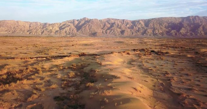 Drone over Dry desert Arava Rocky Desert. Israel Aerial Drone Of Middle Eastern Desert Convoy Tourism.Sand sandy desert and clouds kibbutz in southern Israel