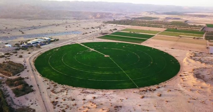 Aerial above agricultural circle plantation in the middle of desert Israel. Circular green irrigation patches for agriculture in the Negev desert of Israel