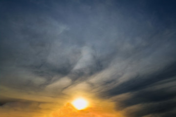 Blue sky with gold clouds - dramatic sunset, beautiful natural background. Setting sun illuminates the clouds.
