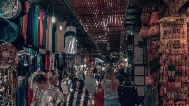 Hyper lapse walking through a crowded indoor market place in Marrakesh Souk Morocco full of stalls and people selling a variety of colorful items
