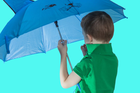 Young boy rear view in a green t-shirt on a blue background. Portrait of a cute toddler boy under an umbrella.