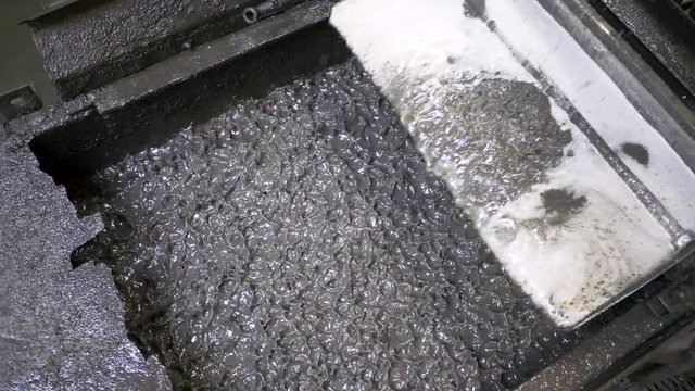 Water vibrating to sift metal flakes in a recycling plant