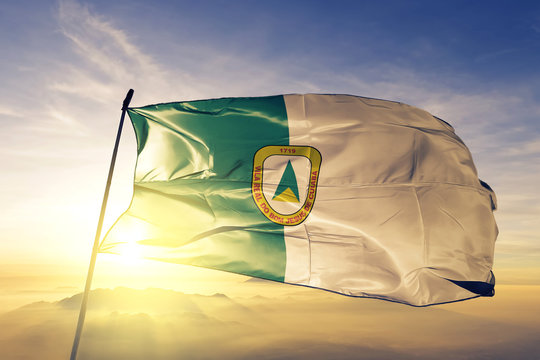 Cuiaba city of Brazil flag waving on the top sunrise mist fog