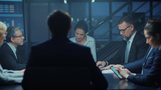 In the Corporate Meeting Room: Diverse Group of Business Associates and ExecutivesTalking, Negotiating, Debating, Working with Documents, Planning Strategy. Late at Night in the Office. High Angle
