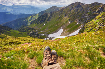 Hiking boots having fun and enjoying wonderful breathtaking mountain view.