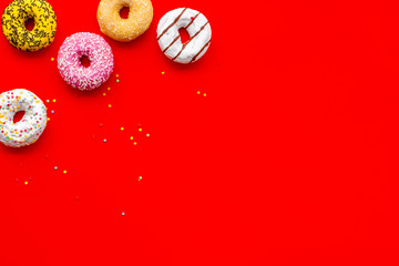 Traditional american donuts of different flavors on red background flat lay mockup