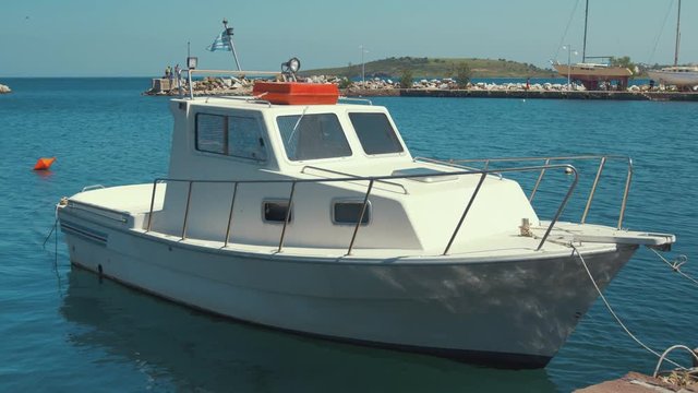 Small plastic cruiser moored at quite Greek village harbor