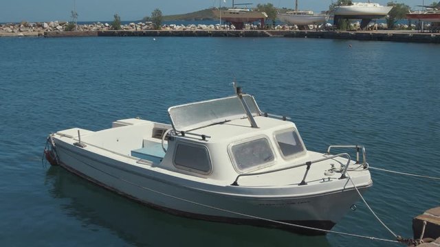 Small plastic cruiser with aluminium windows moored at quiet seaside harbor