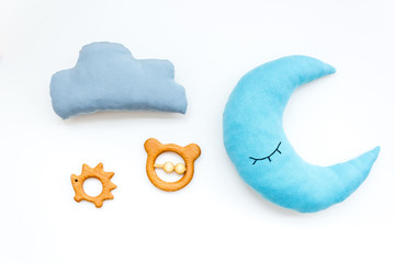 Put baby into bed with moon pillow, clouds and toy on white background top view