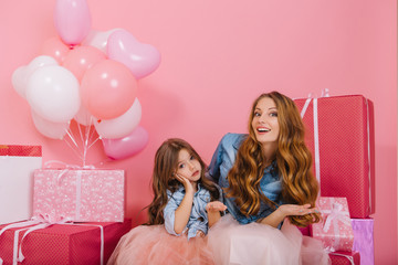 Attractive curly mom and little daughter in beautiful lush skirts fooled at childrens event. Cute...