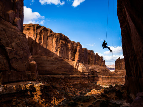 Free-hanging Rappel into Arches National Park canyon in Southern Utah desert.