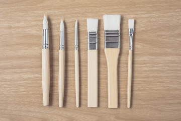 Paintbrush on brown wood table.using for Arts and Education background