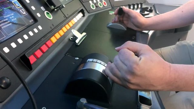Train Driver Hand On Thrust Lever Of Dashboard Controls In Cockpit Cabine.