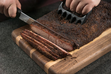 Brisket ahumado cortado en rebanadas en tabla de madera
