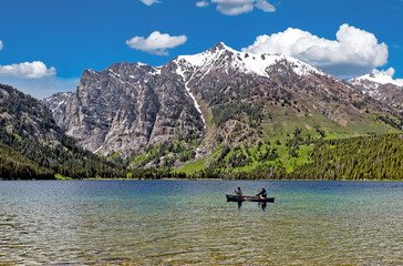 Fototapeta na wymiar Canoers on a clear mountain lake