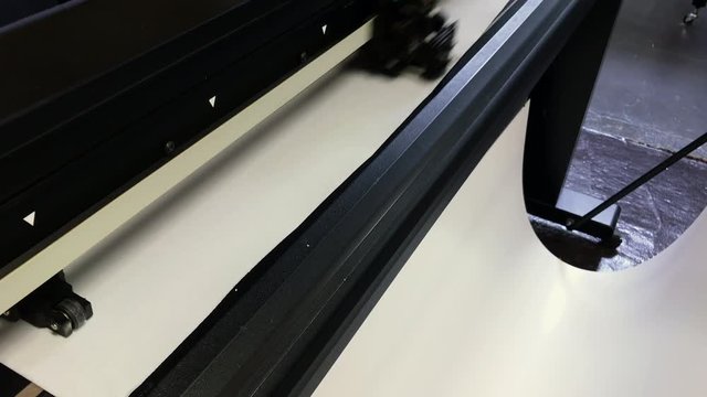 a cutting plotter at work on white vinyl for a graphic design