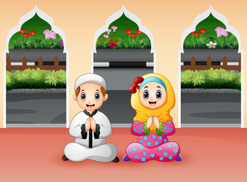 Muslim boy and girl are praying at Mosque