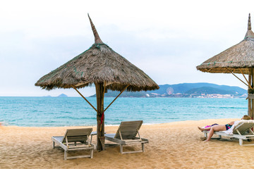 Parasol with loungers on beach near blue ocean