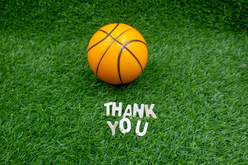 Basket ball with thank you word on green grass