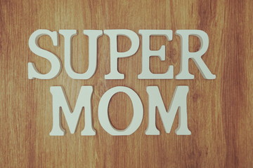 Super Mom Word alphabet letters on wooden background with vintage filter color