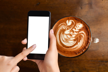 hand playing smartphone with coffee on woodtable