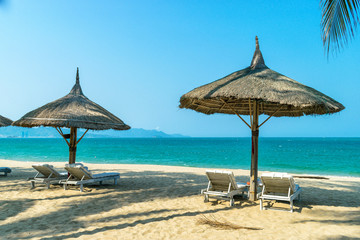 Idyllic landscape paradise scene at the beach side with loungers on clear blue sky day